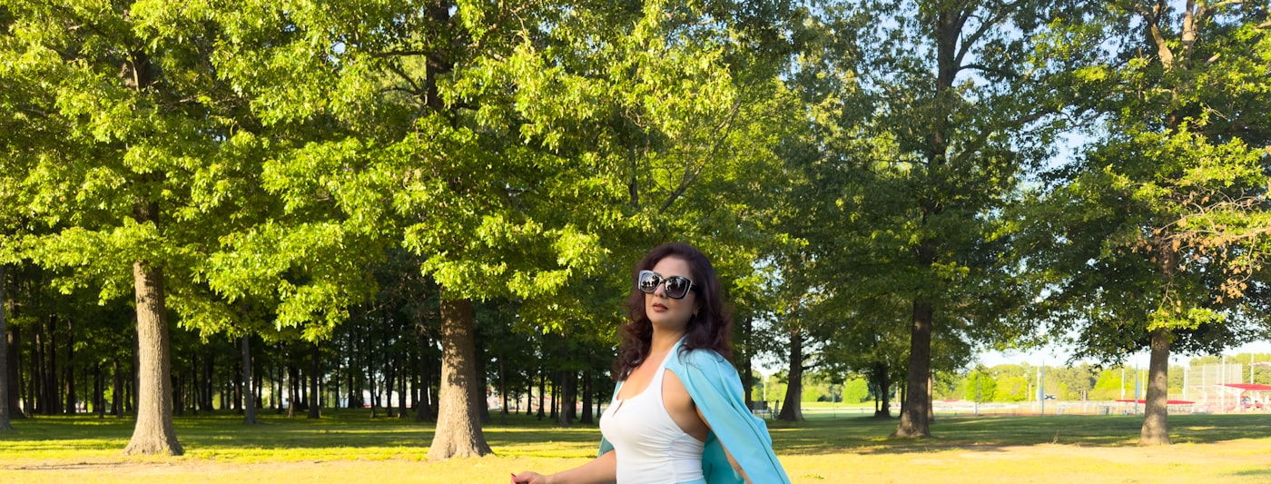A woman walking along a paved path in a park